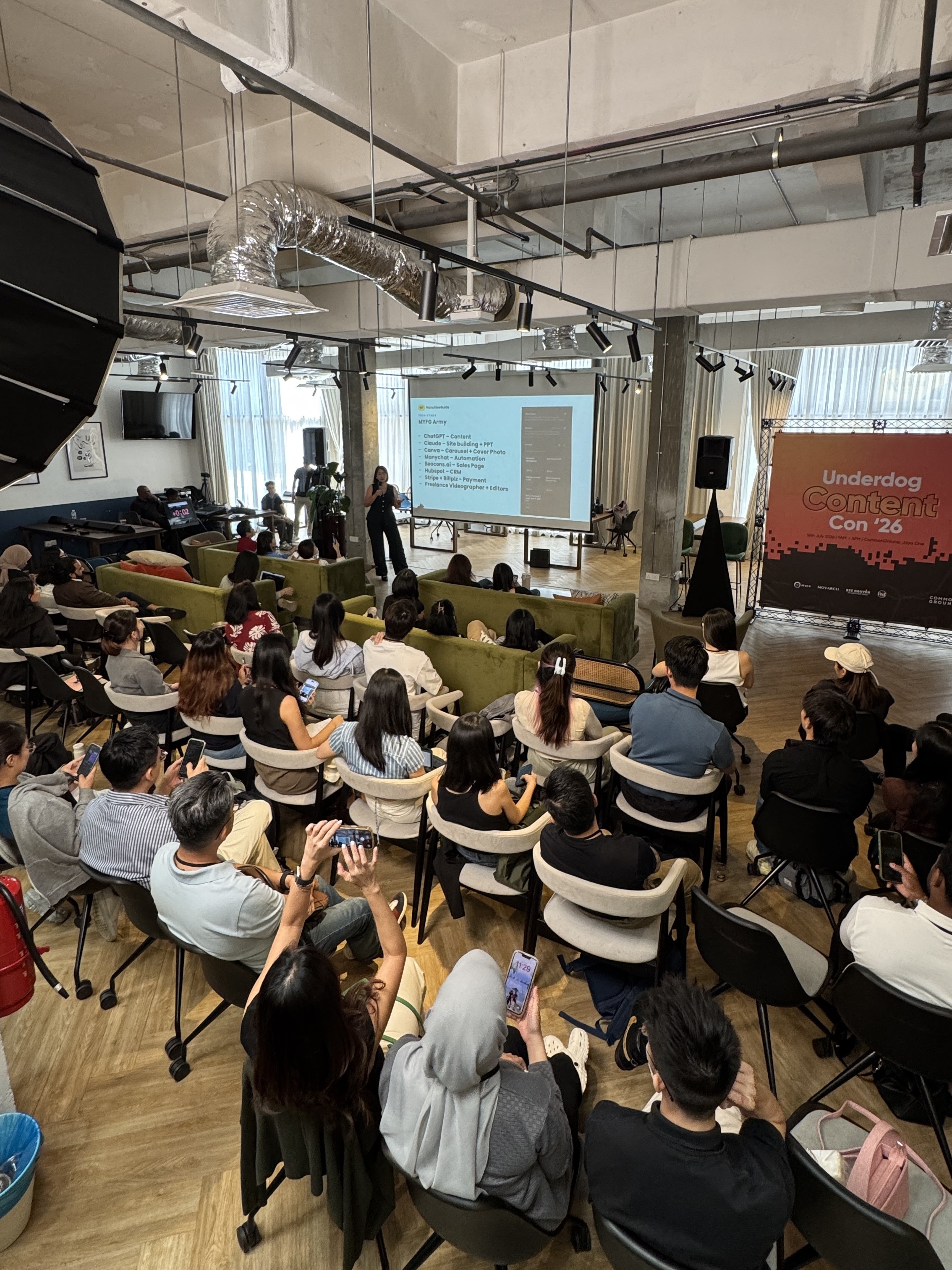 Claudia Ng presenting the MYFG Academy content playbook live on stage to a full audience at Underdog Content Con